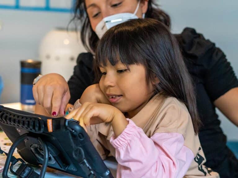 A girl using the QuickTalker Freestyle to communicate.