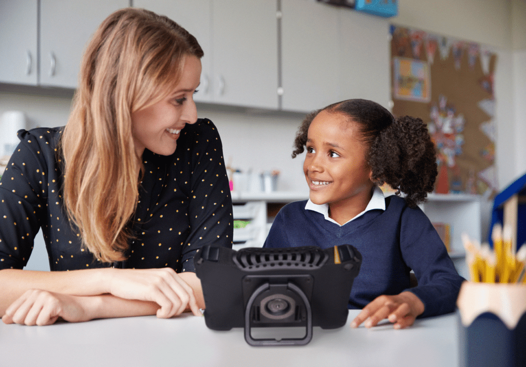 SLP and child engaging with high-tech AAC device for enhanced communication.