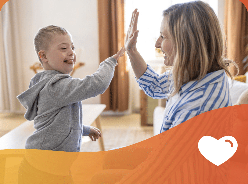 Mother and son sharing a joyful high-five moment together at home.
