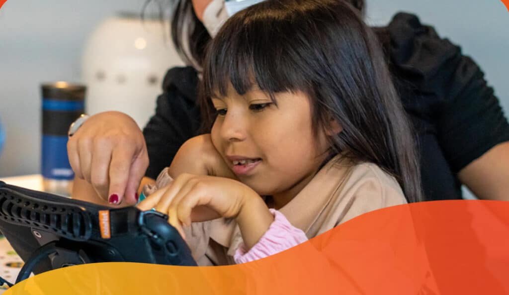 A child enjoys discovering their first smartphone with an adults guidance.