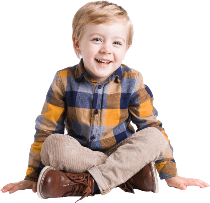 Happy child sitting comfortably, enjoying a joyful moment indoors.