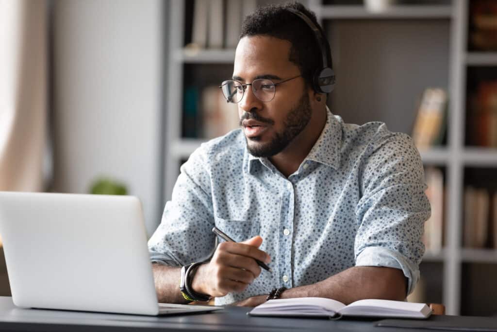 Young businessman focused on online learning during a webinar session.