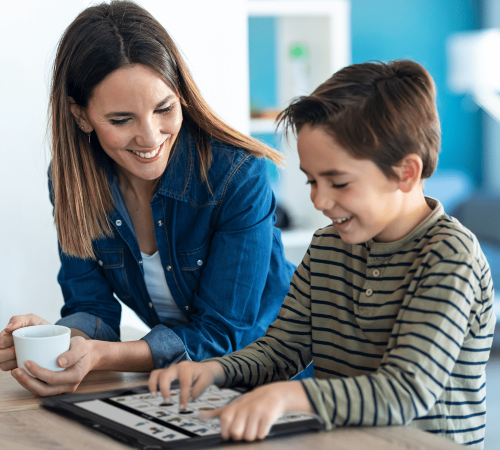 Mother and son engage in a fun learning session using interactive technology together.