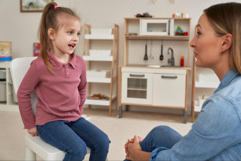 Child and adult engaged in a meaningful conversation in a cozy room setting.