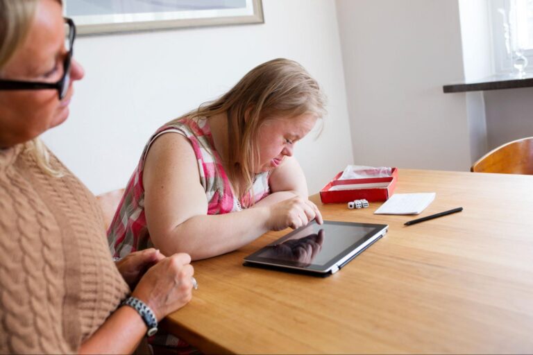 Child engaging with a tablet, learning through interactive technology in a supportive environment.