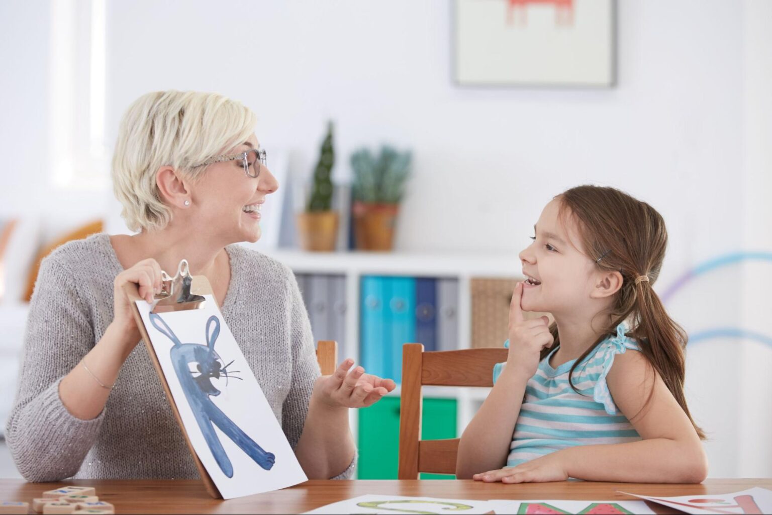 Grandma and granddaughter enjoying creative art together at the dining table.