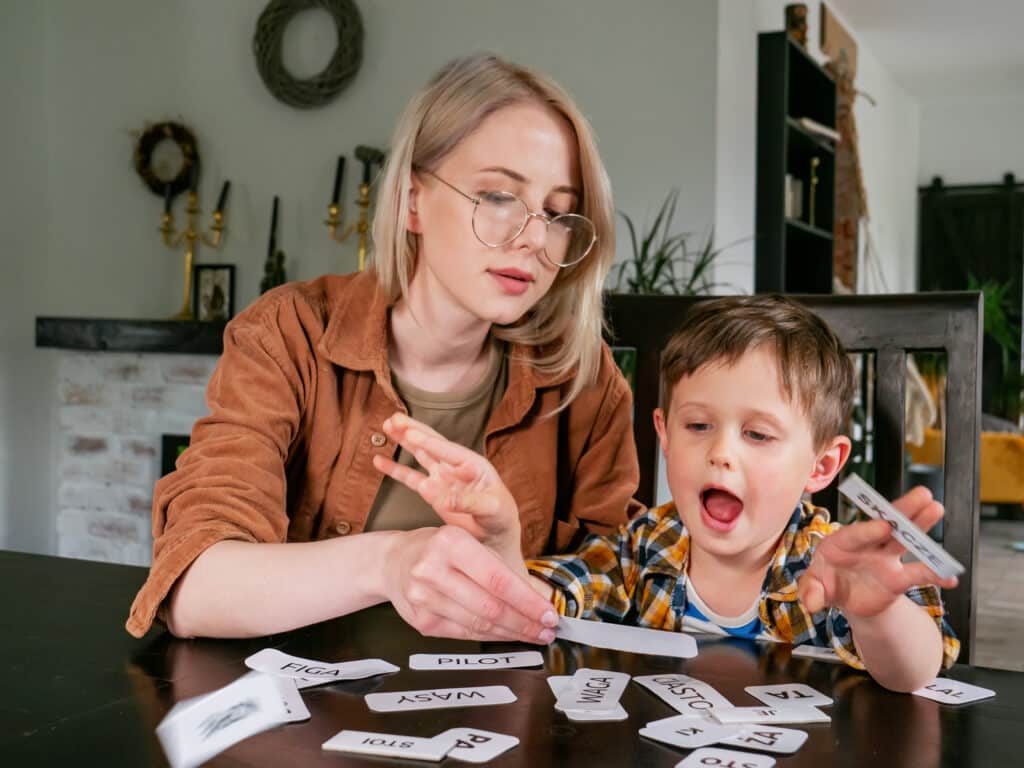 Mom and son play word games at home, learning together with fun flashcards.
