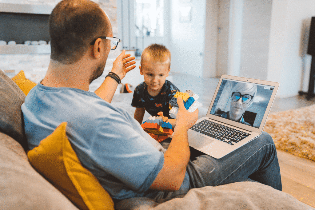 Father and son enjoying a virtual call while playing with toy blocks.