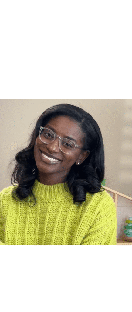 slp spotlight Woman smiling in a bright yellow sweater, radiating happiness and warmth.