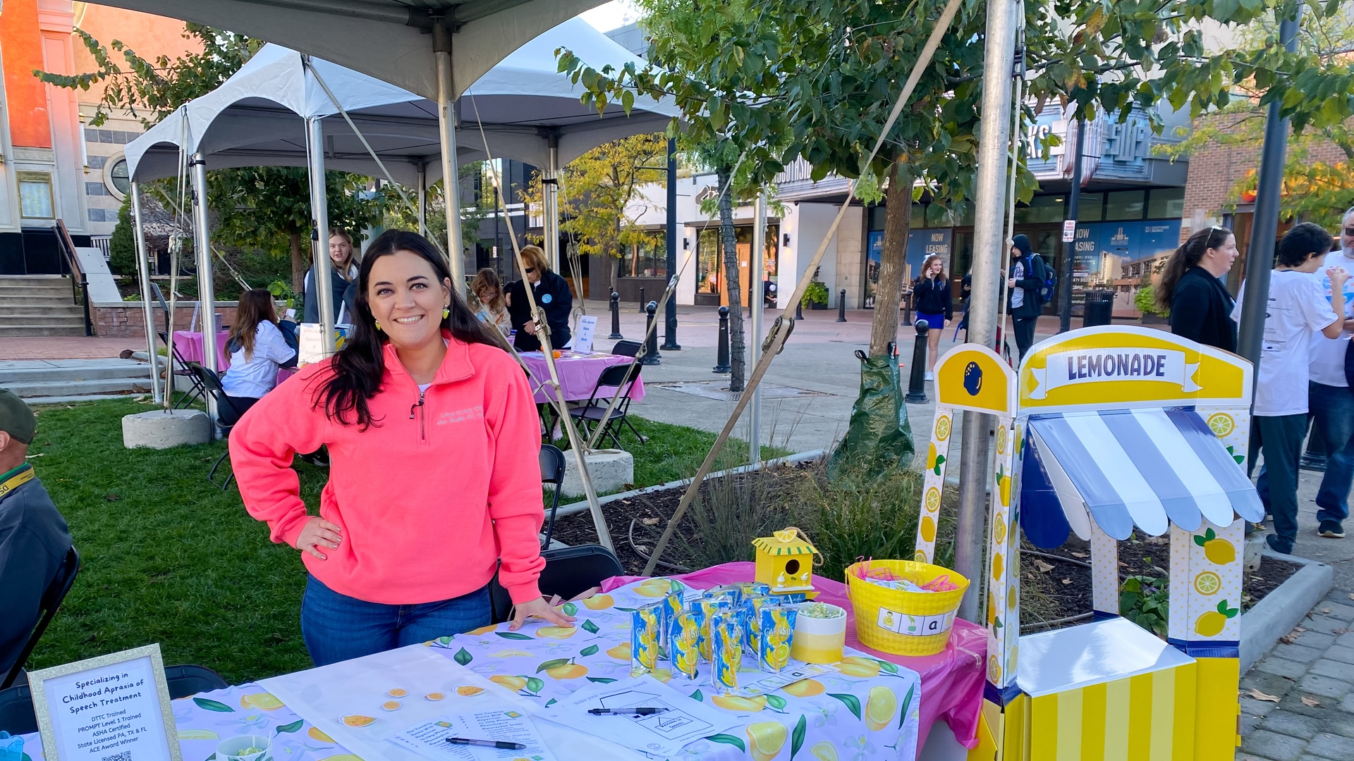 Local lemonade stand event with cheerful vendor and vibrant setup in the park.