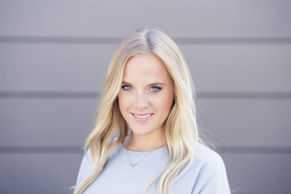 Smiling blonde woman in a casual sweater with beautiful blue eyes.