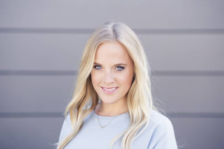 Smiling blonde woman in a casual sweater with beautiful blue eyes.