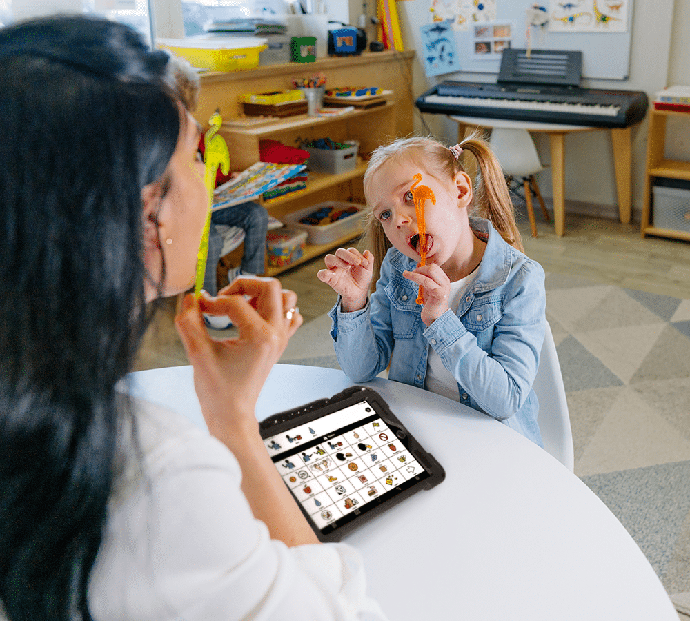 Child engages with teacher using a tablet for interactive learning and playtime activities.