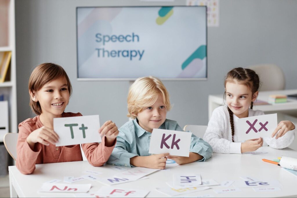 Kids actively participating in engaging speech therapy activities with letter cards.