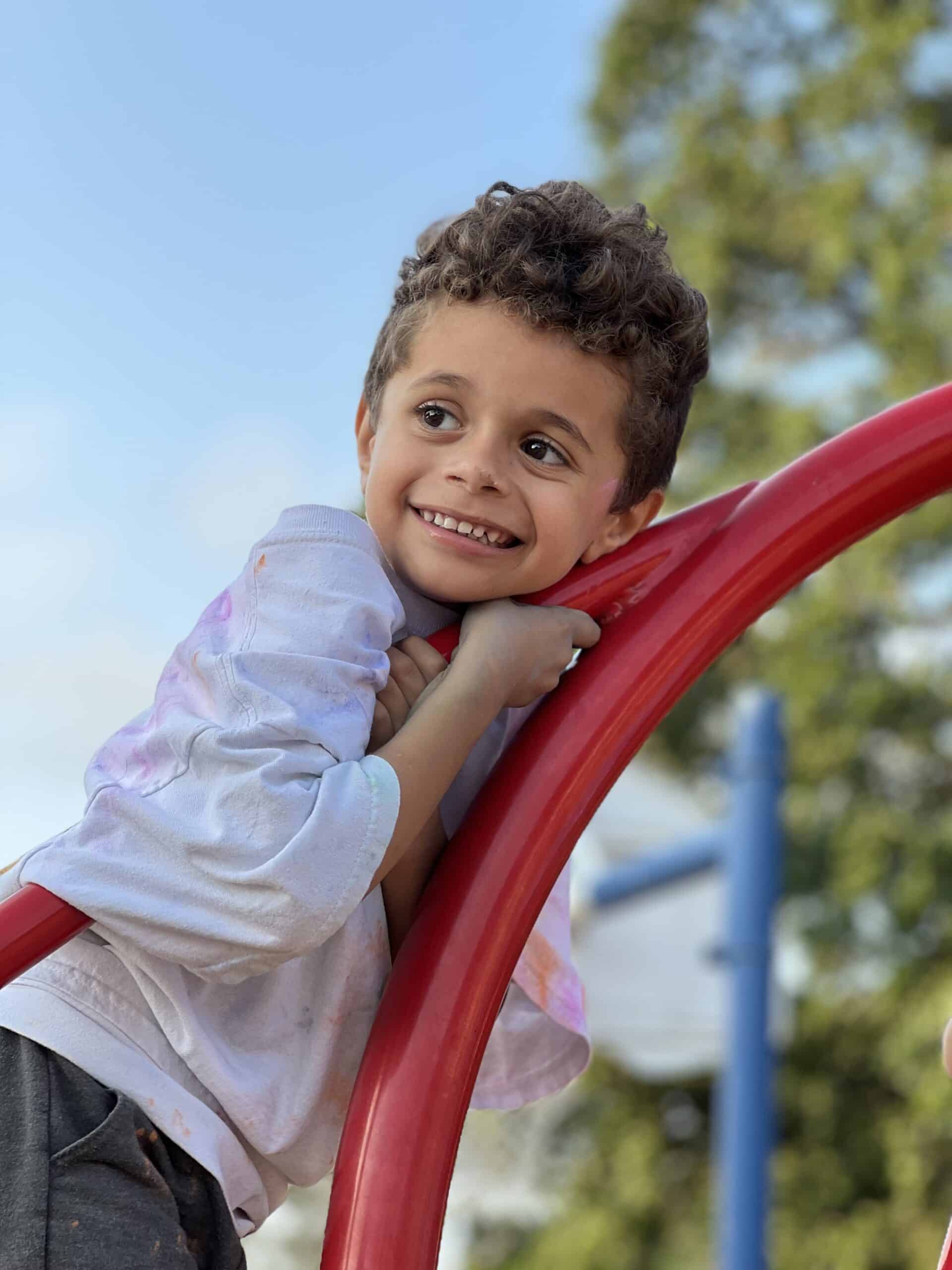 Joyful child playing at the playground, enjoying a sunny day outdoors.