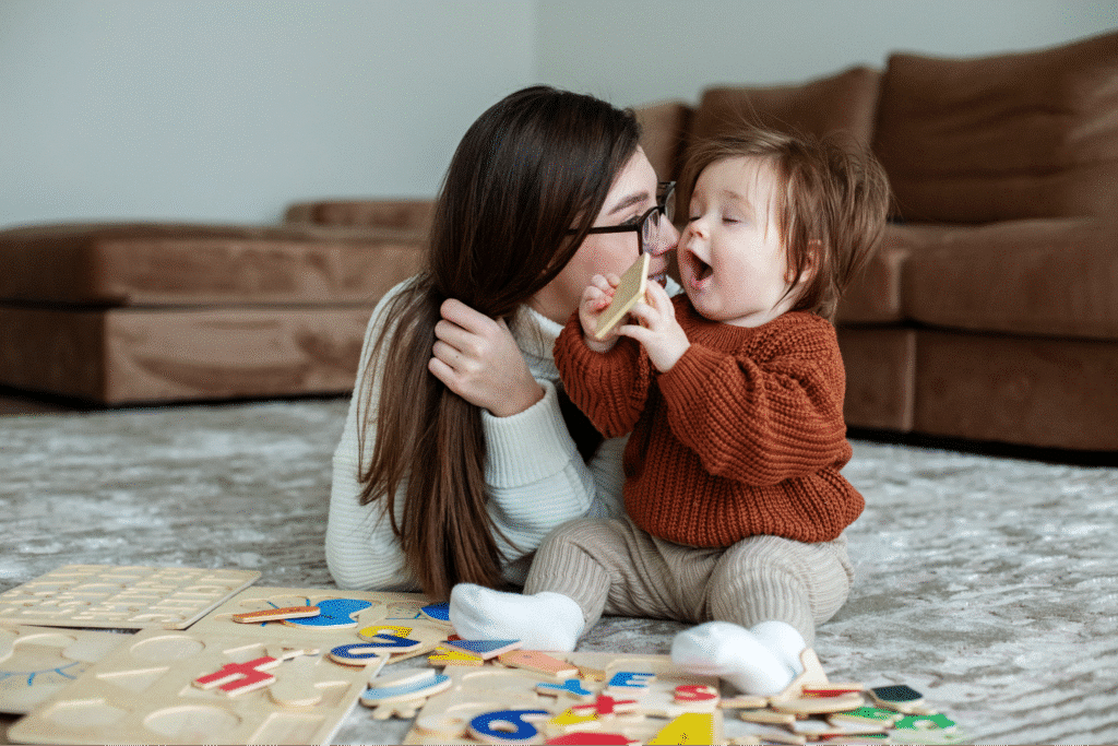 Mother and child engaging with colorful alphabet toys on a cozy living room floor.