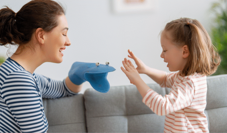 A mother and daughter enjoy playful puppet fun together on a cozy couch.
