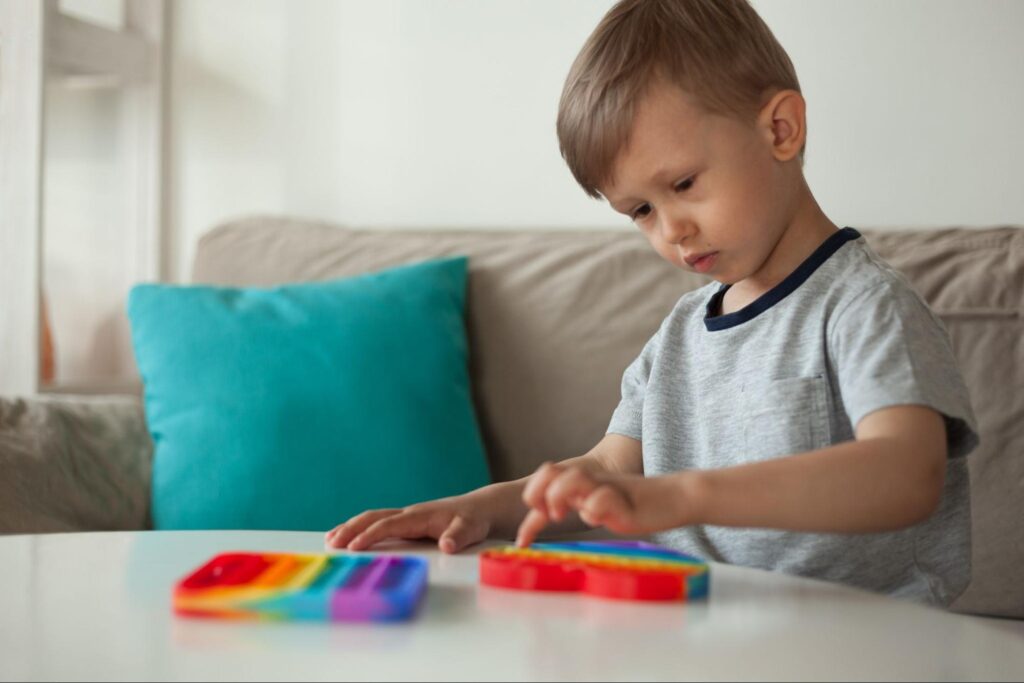 Child playing with colorful toys on a table in a cozy room.