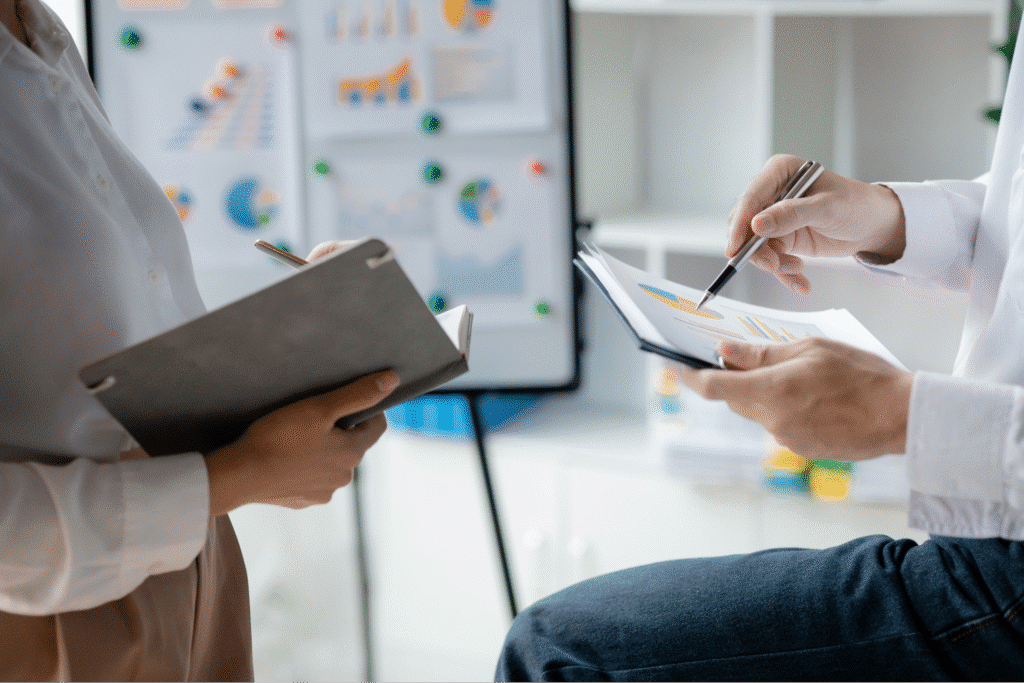 Collaboration on business strategies with notepad and tablet in a modern office setting.
