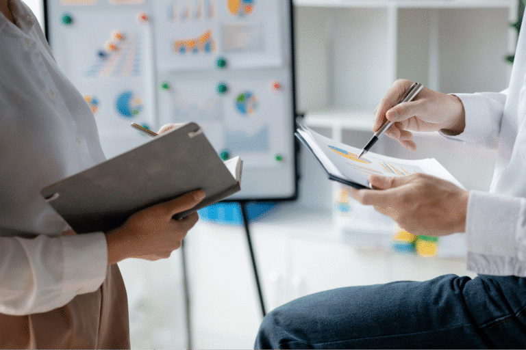 Collaboration on business strategies with notepad and tablet in a modern office setting.