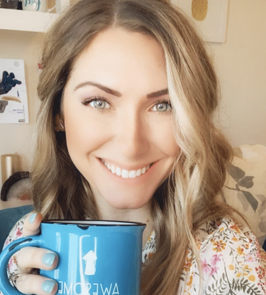 Smiling woman holding a coffee mug in a cozy setting.