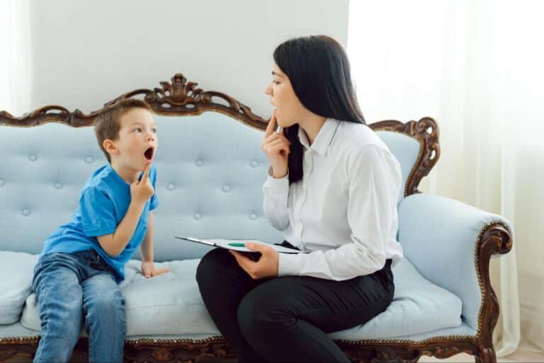 Child and adult engaging in playful communication while seated on a vintage couch.