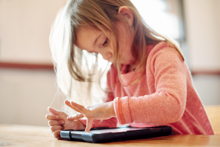 Child engaged with tablet, learning and exploring technology in a cozy environment.