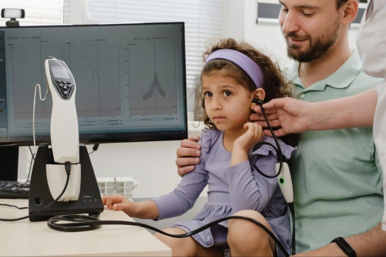 Child undergoes hearing test with parent in a modern clinic setting.