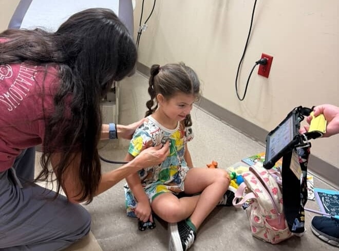 Child health checkup with a doctor examining a young girl in a medical office.