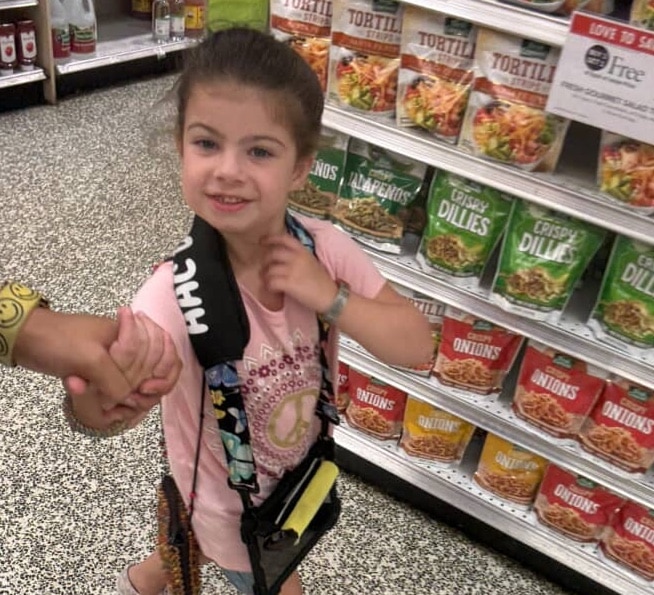 A young girl enjoys a fun shopping adventure in the store aisle.