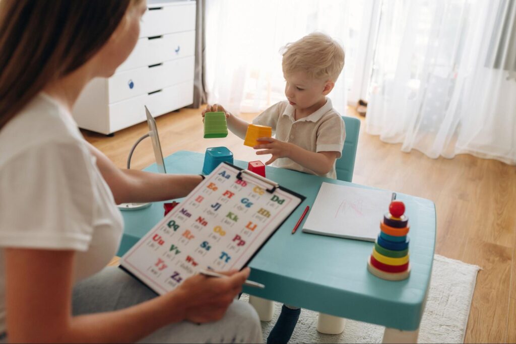 Child stacking colorful blocks with adult guidance for creative learning and fun.