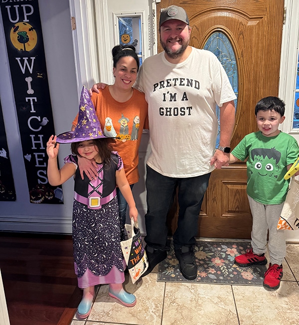 Happy family in Halloween costumes, celebrating with fun and treats at home.