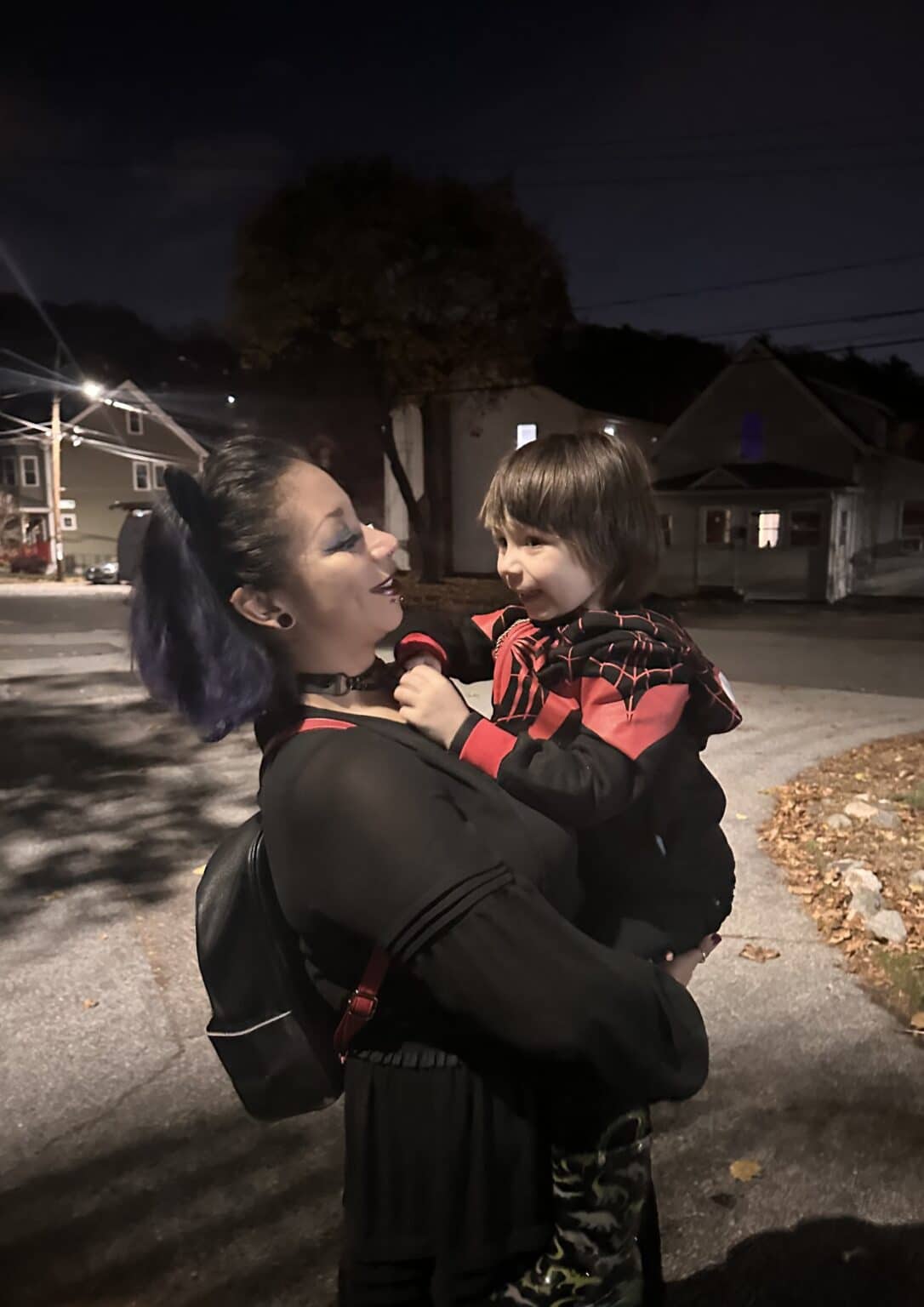 A joyful night moment with a mother and child sharing smiles outdoors.