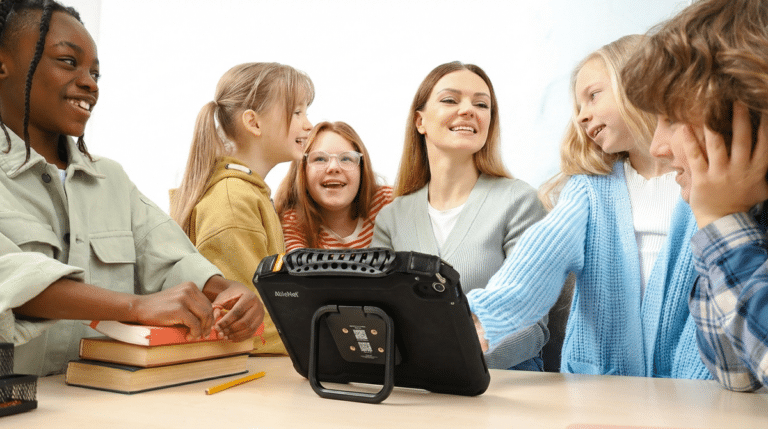 Children using QuickTalker Freestyle for interactive learning in a vibrant classroom.