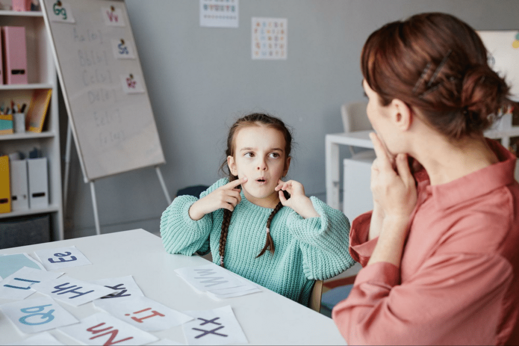 Child engaging in speech therapy with a speech-language pathologist using interactive lessons.