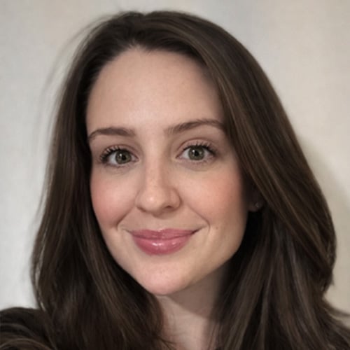 Cheerful woman smiling in a close-up portrait, showcasing healthy skin and vibrant eyes.