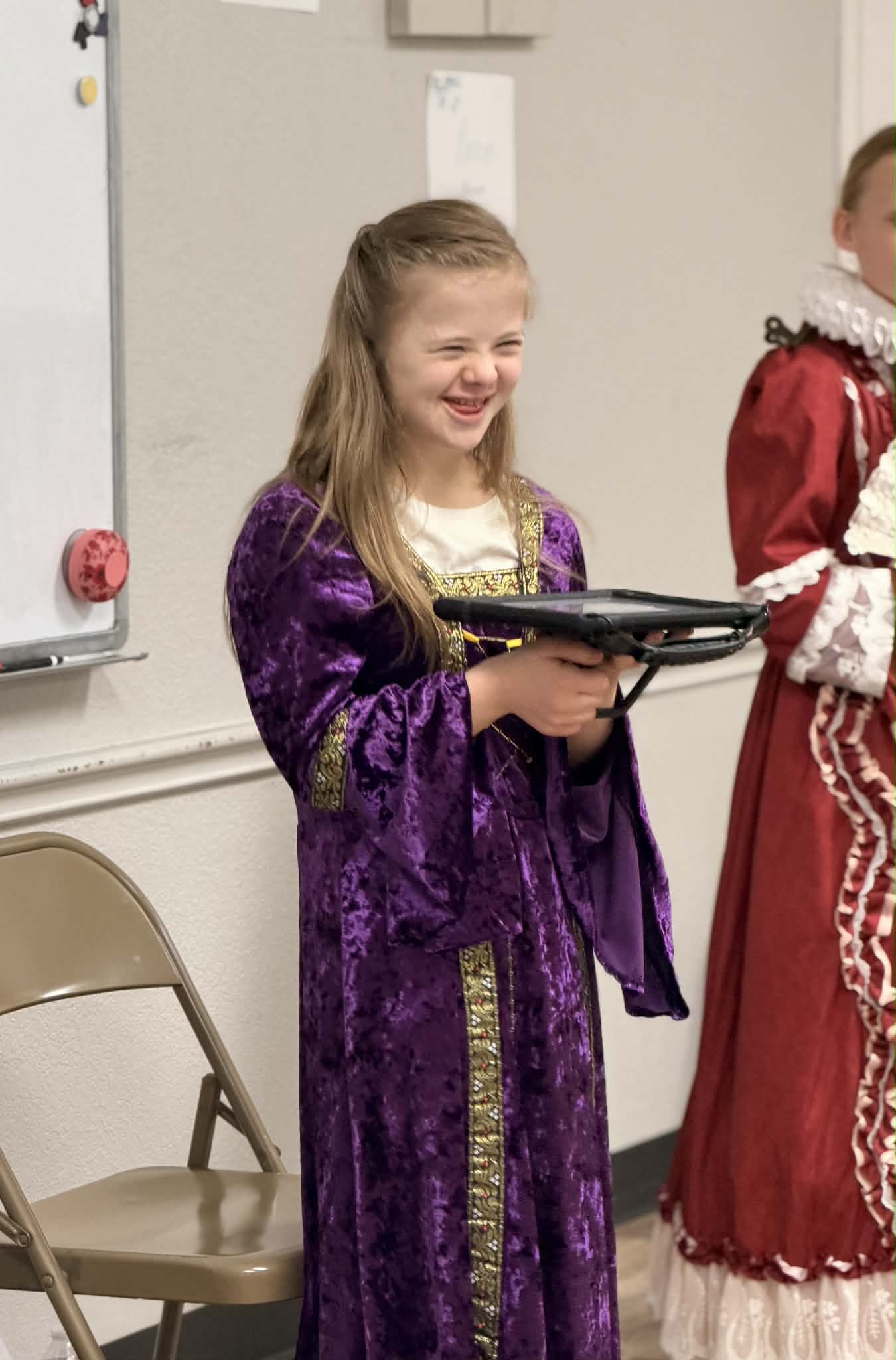 Girl in a purple costume smiles joyfully at the AbleFamilies event.
