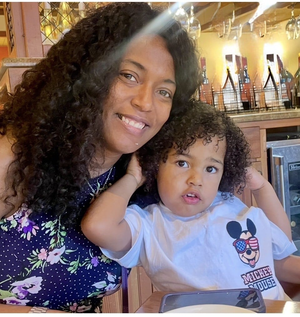 A smiling mother and child enjoying a joyful moment together in a warm setting.