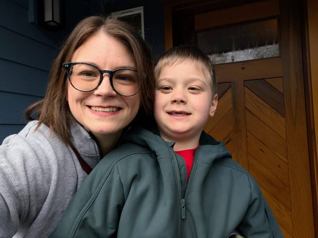 Dana smiles in a selfie with her son Logan on the front porch of their home.