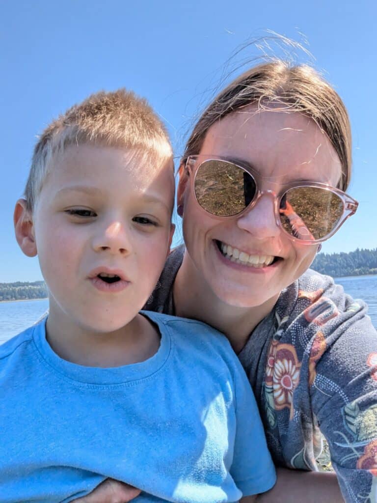 Logan and his mom, Dana, smile together outside on a sunny day.