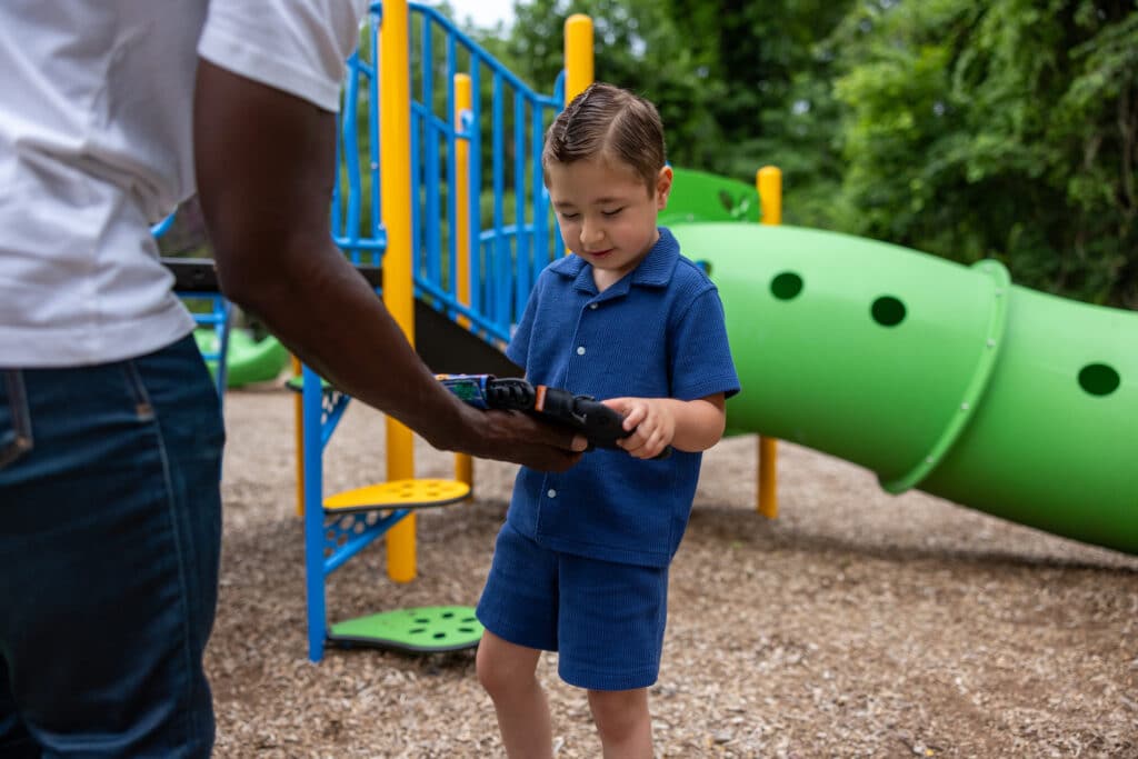 Child using a Quicktalker Freestyle device at the playground, engaging in communication.