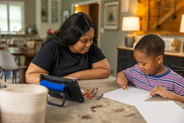 Engaging in creative drawing at home with Quicktalker Freestyle device and family.