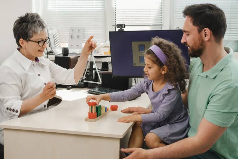 Speech therapist engaging with a child using toys to enhance communication skills.