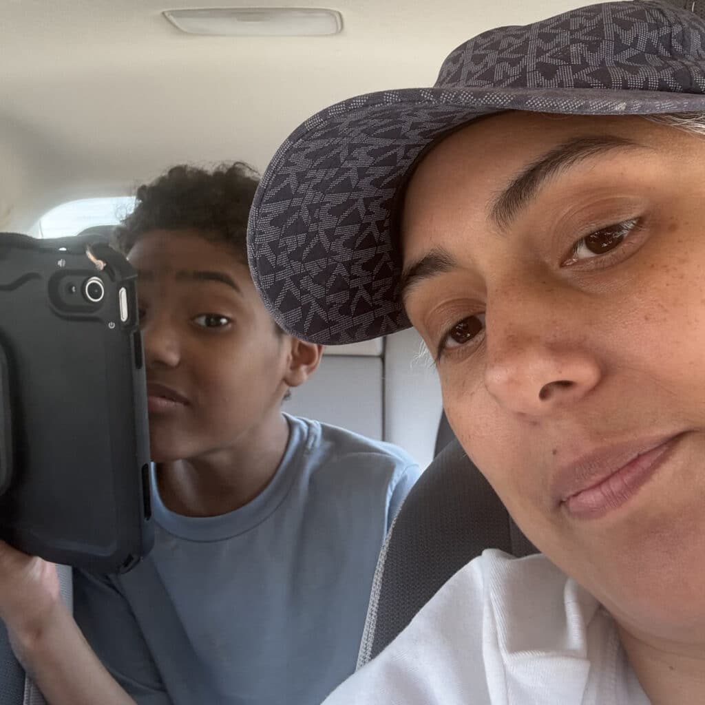 Mom and son enjoying a fun car selfie together during a joyful ride.