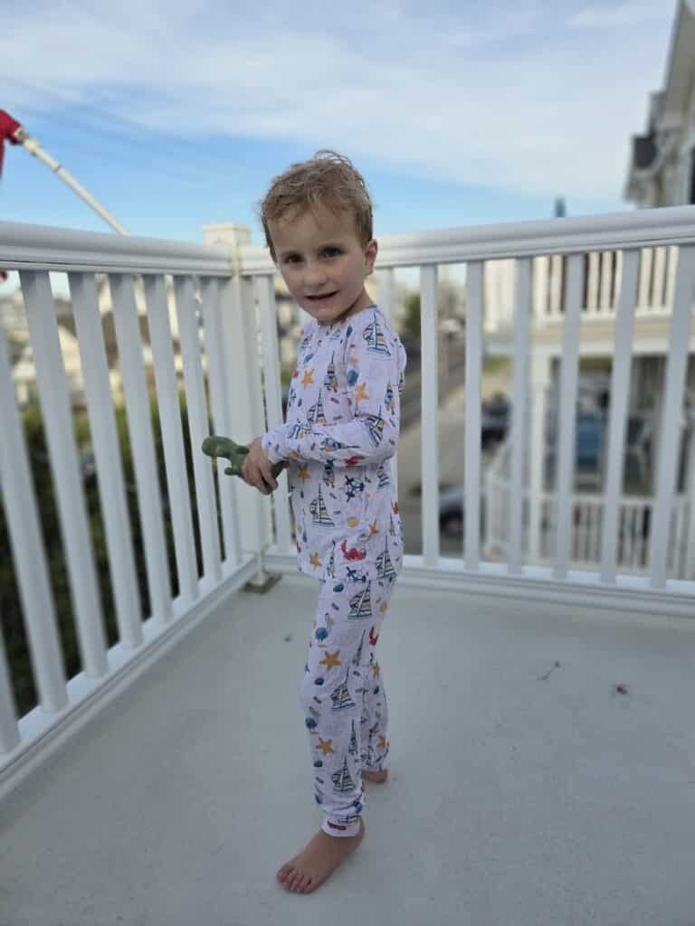 Child in fun pajamas enjoys playful moments outdoors with family.
