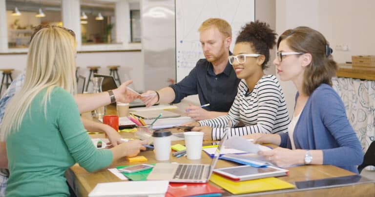 Diverse group of SLP professionals brainstorming ideas at a collaborative workspace table.