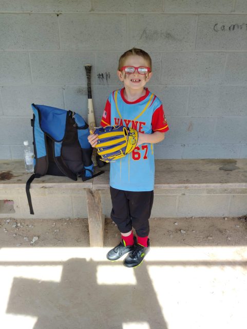 Smiling boy with a baseball glove, ready for fun family sports moments.