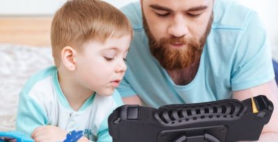 Dad and child enjoying quality time while using the high-tech AAC QuickTalker Freestyle device.