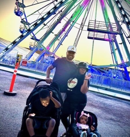 Family enjoying fun activities at a vibrant fair with a ferris wheel backdrop.