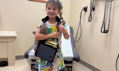 Cheerful child holding a toy at the doctor’s office ready for a check-up.